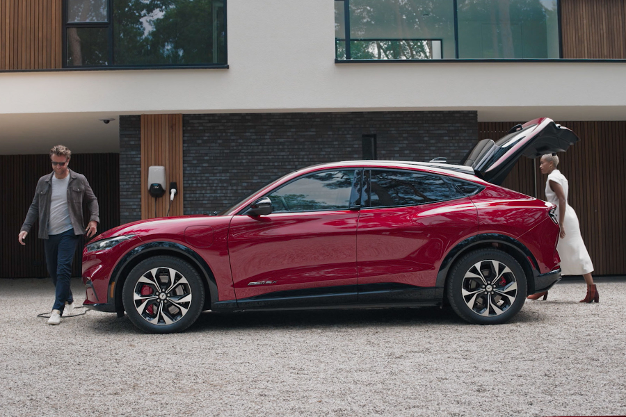 Ford Mustang Mach-E in Rot, AWD. Seitenansicht mit geöffneter Heckklappe